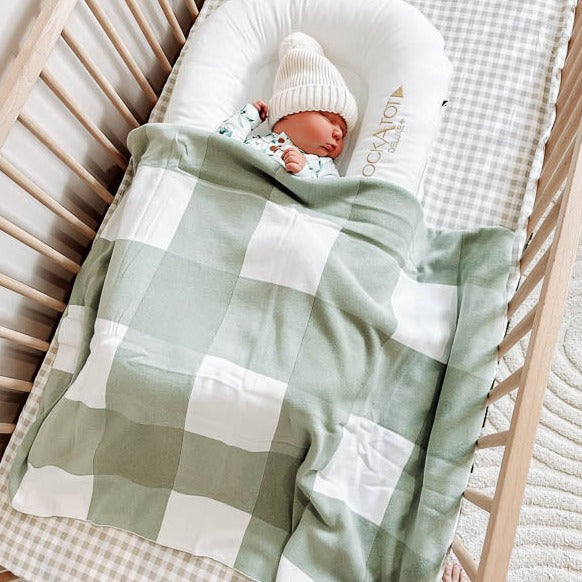 A large and luxurious green gingham knitted blanket made of organic cotton by Snuggly Jacks