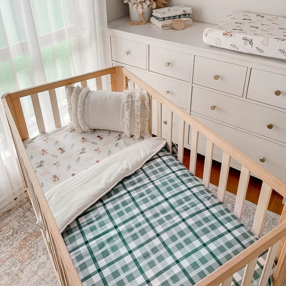 Nursery set with a collection of dragon prints matched with a blue cyprus plaid crib quilt