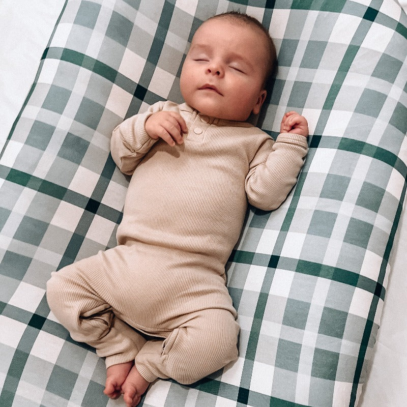 A sleeping baby using a baby lounger from snuggle me organic