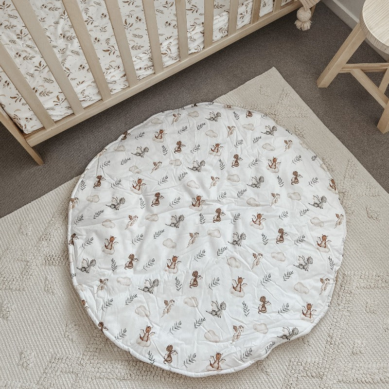 Over head shot of a whimsical dragon printed play mat set out on the floor 