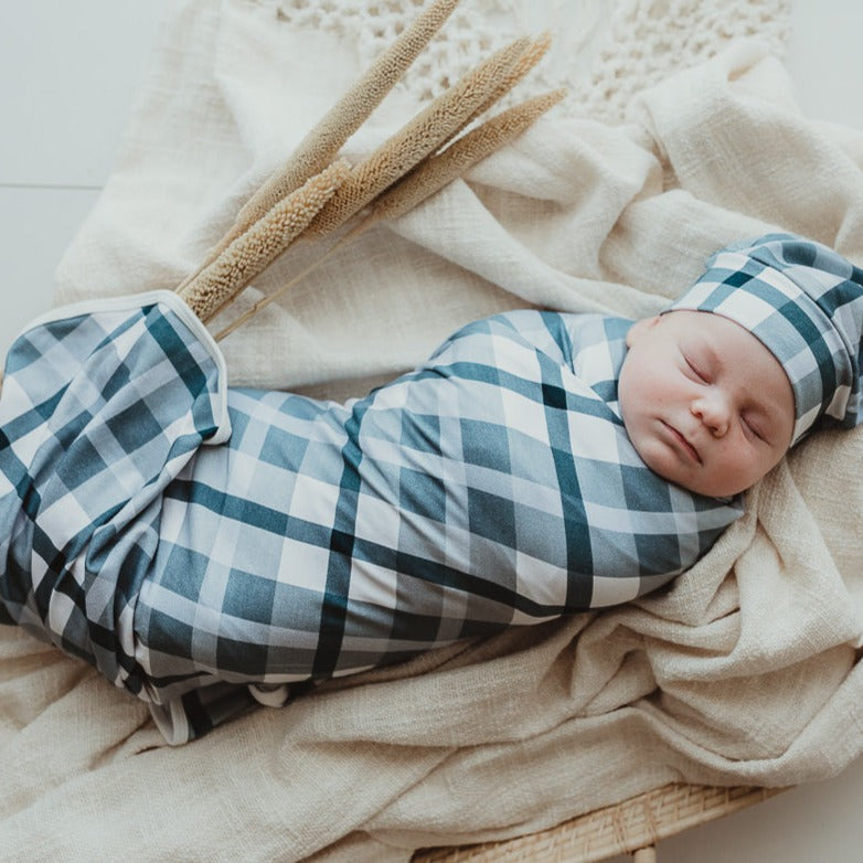 A blue jersey swaddle stretch wrap keeping a sweet little baby all snug and well rested. 