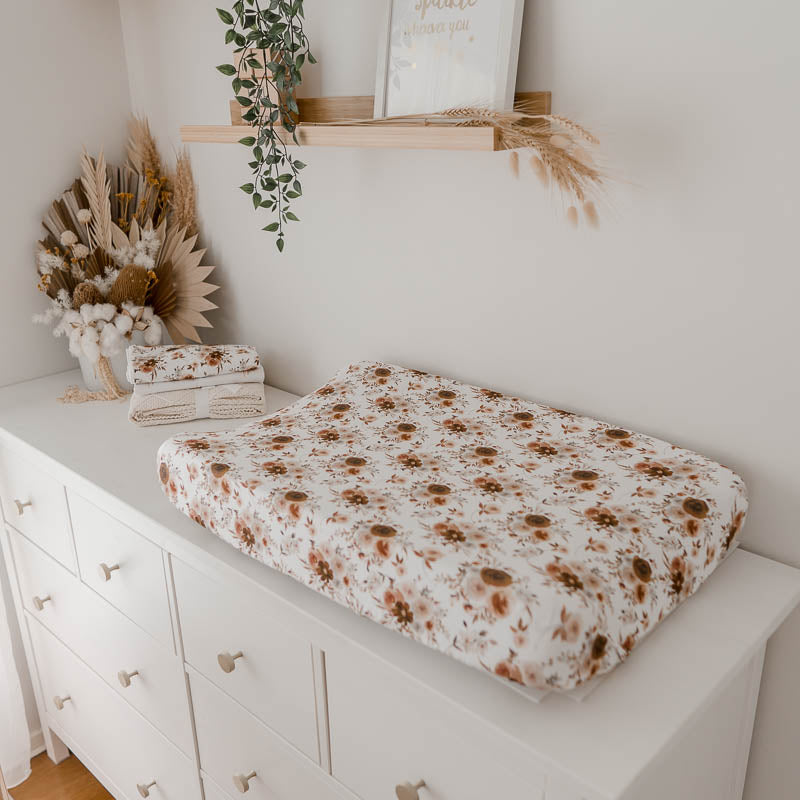 White pine chest of draws with a floral change pad in the foreground 