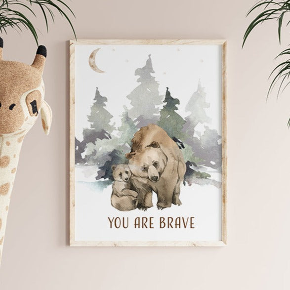 Picture of a brown bear and her cub walking in the forest, in a brown frame hanging on a nursery room wall